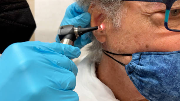 Earwax microsuction by Waxedears Senior caucasian man is at the doctor having his ear checked to see if he has wax in his ear that needs to be removed.