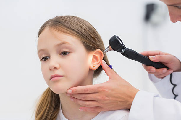 Waxed Ears child service II General practitioner auscultating the ear of a patient with a otoscope in a hospital