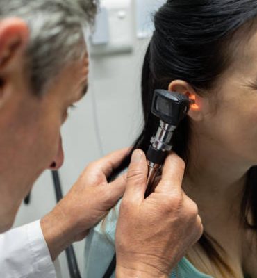 Mid section of Caucasian male doctor examining a pregnant Caucasian woman in examination room of the hospital