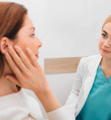 Doctor listens to the patient's complaints while the patient points to the ear. Otitis, showing ear pain